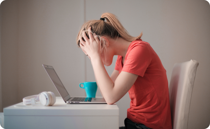 Photo d'une femme se tenant la tête devant son ordinateur